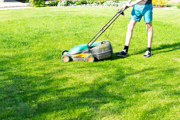 young man mows the lawn.