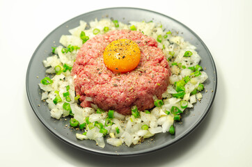 Beef steak tartare with raw egg yolk and onion with chive