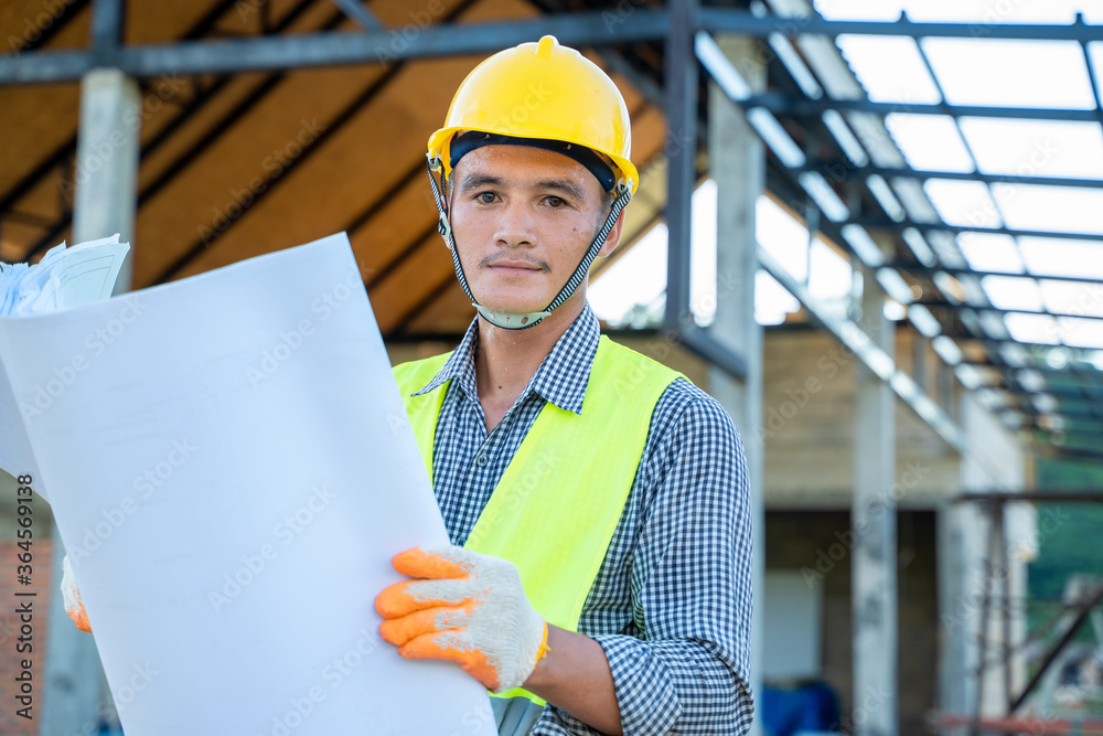 Poster engineer working new project of building blueprints in construction site,serious civil engineer work