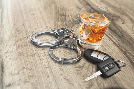 Whiskey with car keys and handcuffs concept for drinking and driving