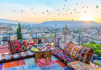 Traditional turkish breakfast with Cappadocia view and flying balloons on the background. Goreme,...