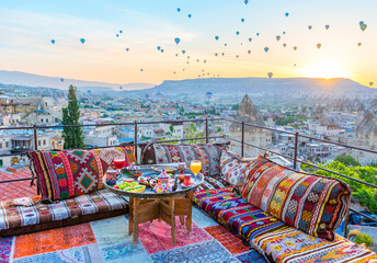 Traditional turkish breakfast with Cappadocia view and flying balloons on the background. Goreme, Turkey..