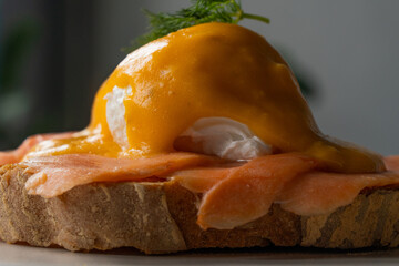 Delicious eggs Benedict with smoked salmon, hollandaise sauce and parsley.