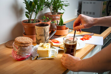 Fototapeta na wymiar Making cup of coffee and sandwiches in the morning. Photo of breakfast making process in a kitchen. 