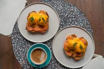 Delicious eggs Benedict with smoked salmon, hollandaise sauce and parsley.