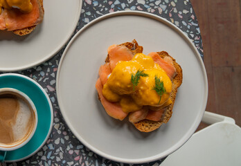 Delicious eggs Benedict with smoked salmon, hollandaise sauce and parsley.