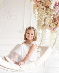 Little beautiful girl with a caret in a white dress on a white ring