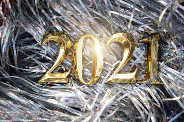 Happy new year 2021 - golden number on a silver background from tinsel. Shiny Christmas...