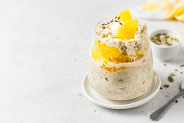 Orange honey oatmeal porridge breakfast in glasses. Slective focus, copy space.