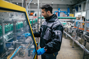 Fototapeta premium Male worker working in bottling factory. Inspection quality control.