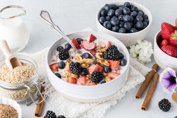 Hot steel cut oatmeal topped with berries and walnuts ready for eating.