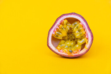 Selective focus. tropical tasty fruit with seeds cut in half on a yellow background. Close up 