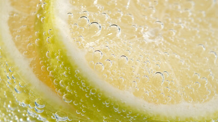 refreshing soda tonic fizzy water, lemon in glass macro close-up. Slice of lemon, mineral bubbles....