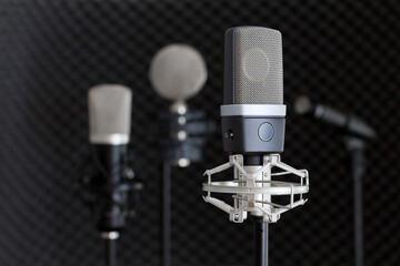 Recording studio equipment. Microphones on stands in music recording studio on black dark background.