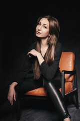 Fototapeta na wymiar Beautiful brunette in the studio on a dark background in a photo studio