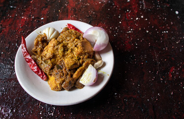 Closeup of Mangsho Kosha or Bengali Style Chicken Curry Isolated on Reddish Background with Copy Space