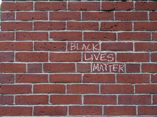 Fototapeta na wymiar Black Lives Matter slogan scrawled in chalk on a brick wall, right justified horizontal