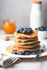 Pancakes with blueberries and honey on a plate. Tasty pancakes. Toned image