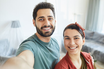 Obraz premium Portrait of young happy couple smiling at camera they making selfie portrait at home