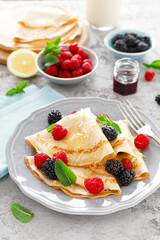 Thin crepes with fresh berries and lemon zest. Pancakes with raspberry and blackberry.
