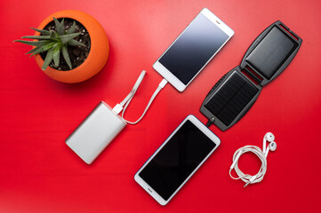 Electric power bank and solar panel. Charging smartphones. Flat lay.