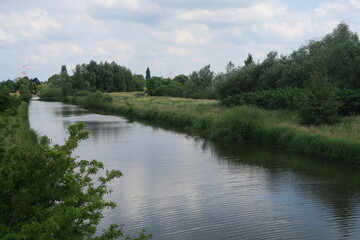 Fototapeta na wymiar Der Fluss Ochtum im Sommer mit dem Sommerdeich daneben