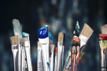 
Paint brushes in front of blurred canvas