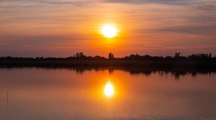 beautiful orange sunset on the lake on a summer day, panoramic shot