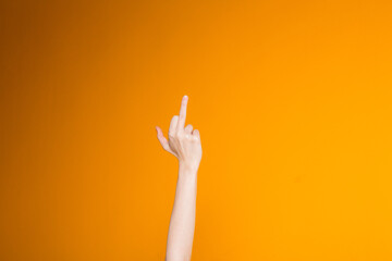 The concept of indecent and defiant gestures. Female hand shows the middle finger on the right of...