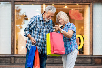 Happy senior couple with shopping bags