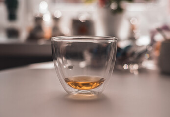 .transparent mug with green tea on the table against the background of the kitchen