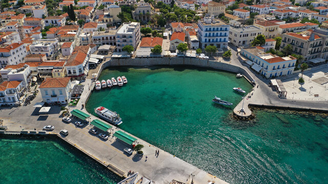Aerial drone bird's eye view photo of picturesque neoclassic houses in historic and traditional island of Spetses with emerald clear waters, Saronic Gulf, Greece