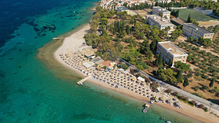 Fototapeta na wymiar Aerial drone photo of organised with sun beds emerald beach of Kaikia in Ligoneri area near old town of Spetses island, Saronic gulf, Greece