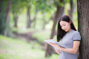 Obraz premium Asian woman is sitting listening to music and smiling with happiness and relaxation. The concept of relaxation with music