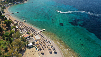 Aerial drone photo of organised with sun beds emerald beach of Kaikia in Ligoneri area near old town of Spetses island, Saronic gulf, Greece