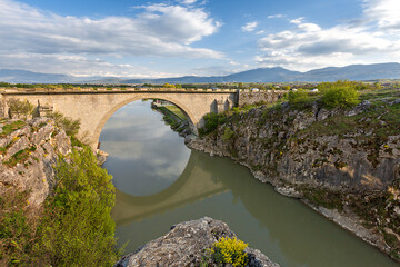 Fototapeta na wymiar Old bridge with its reflections in water, near Prizren, Kosovo.