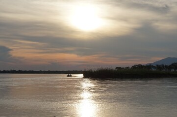 Zachodzące słońce nad rzeką Zambezi z pływającymi hipopotami i krokodylami w Parku Narodowym...