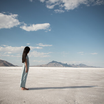 Side view of teenage girl standing on salt flat