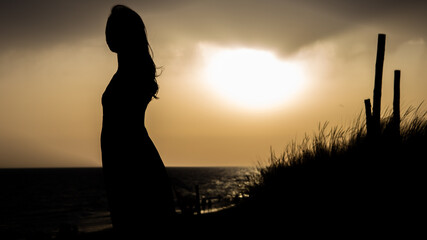 Fototapeta premium Chica vestido puesta de sol playa