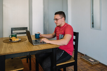 Man using his laptop and drinking coffee.