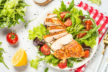 Grilled chicken with fresh salad at table.