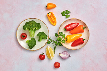 Tomato, bell pepper, broccoli, onion. Vegan diet food, creative composition on marble. Cherry tomatoes, red orange bell pepper layout, cooking salad colorful concept, top view.
