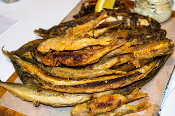 Fried small fish on wooden board