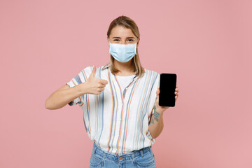 Young girl in striped shirt face mask isolated on pink background. Epidemic pandemic coronavirus...