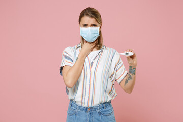 Sick woman in casual striped shirt sterile face mask isolated on pink background. Epidemic pandemic...