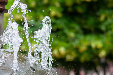Water gurgling from a street fountain. A splash of water in a fountain, an abstract image.