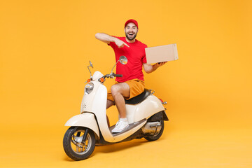 Delivery man in red cap tshirt uniform driving moped motorbike scooter hold cardboard box isolated...