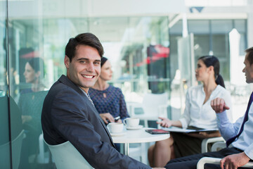 Smiling businessman in meeting at sidewalk cafe