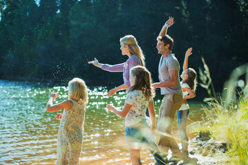Family skipping stones at lakeside