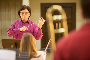 Conductor leading orchestra in practice © Martin Barraud/KOTO